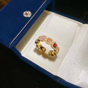 Detail of 14k gold plated ring featuring colorful square-cut zircons on a blue lining
