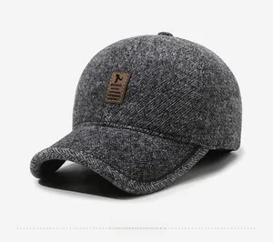 Close-up of a men's winter baseball cap with dark grey tweed texture and leather logo patch