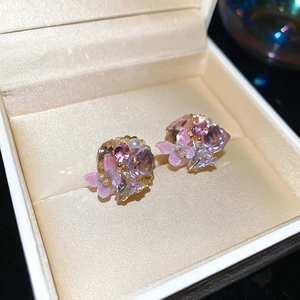 Macro shot of 18k gold plated flower cluster earrings with crystals, pearls and butterflies