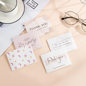 Flat lay of assorted minimalist thank you cards on a warm desk with coffee and glasses