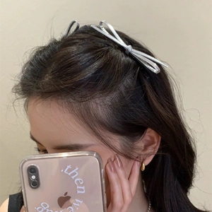 Silver bow hair clips set for women shown on model for a trendy minimalist look