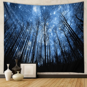 Deep blue starry forest tapestry hanging on wall in a minimalist home setting