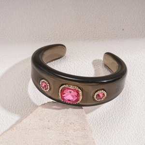 Detailed macro view of resin cuff bangle with pink crystals and micro-diamond settings