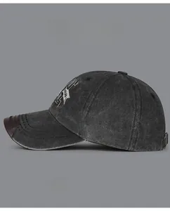 Detail of vintage washed cotton baseball cap featuring 3D letter embroidery and leather brim