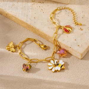 Gold paperclip chain bracelet with enamel bee, ladybug, and crystal butterfly charms