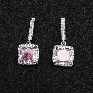 Macro view of square pink gemstone earrings with silver micro-paved white diamonds