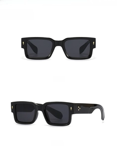 Detail view showing front and side profile of black square sunglasses with gold accents