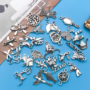 Macro view of assorted vintage silver alloy charms featuring animals and heart patterns