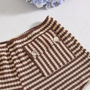 Detail van gestreepte gebreide short met wafeltextuur en metalen knoop decoratieve zakken