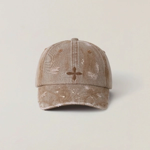 Close-up of vintage khaki baseball cap with cross embroidery and distressed paint effect