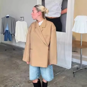Blazer oversize kaki à boutons latéraux porté avec un short en jean et des bottes