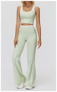 Close-up of light green flared yoga leggings and sports bra with white trim detail