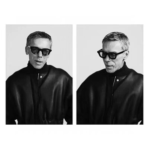 Detail view of square punk sunglasses with black frames on a model in a leather jacket