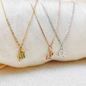 Macro shot of Virgo Capricorn and Leo zodiac pendants in gold rose gold and silver