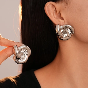 Polished silver knot stud earrings for women featuring a bold metallic twisted design