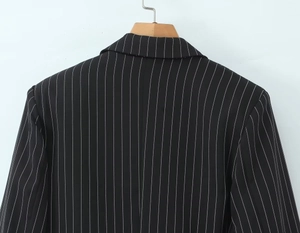 Vue arrière du blazer noir rayé montrant l'ourlet à volants et le tombé professionnel