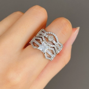 Detailed view of square cut zircon engagement ring set worn on finger for party