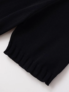 Detailed close-up of the black rib-knit texture and elastic cuffs on the short sleeve jacket