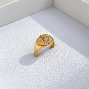Detail view of gold sun and moon signet ring with three zircon stones on white display