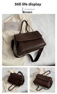 Detail view of coffee brown tote bag with crocodile texture and crossbody strap
