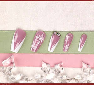 Macro view of lilac Christmas press-on nails with white snowflake and rhinestone details