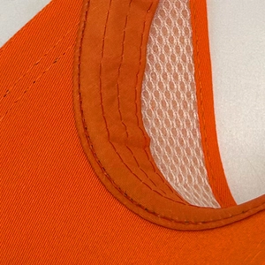 Close-up of orange sun visor stitching and breathable white mesh lining detail