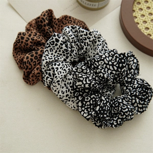 Close-up of leopard print oversized hair scrunchies in three vintage colors and patterns
