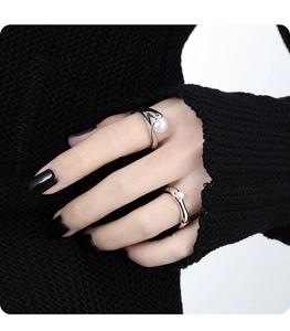 Detail of silver fluid geometric S925 rings with white pearls on a model hand