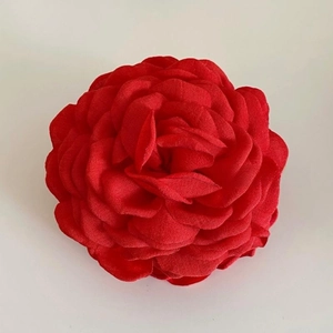 Detailed macro view of the realistic layered fabric rose petals on the red flower hair claw