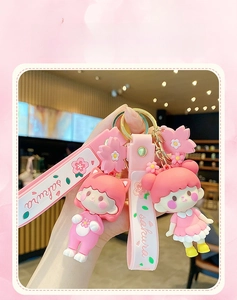 Close-up of pink cherry blossom girl keychains with sakura printed silicone wrist straps