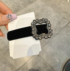 Dettaglio di un fermaglio in velluto nero con una lussuosa fibbia quadrata di strass