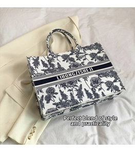 Detailed top view of a blue floral canvas tote bag with elegant handles and patterned texture