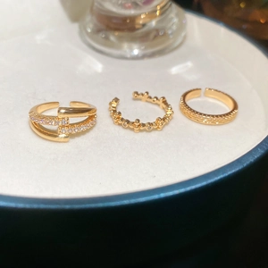 Macro shot of 18k gold plated open rings set with sparkling zircons on a white tray