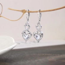 Detailed shot of silver heart earrings with infinity symbol and cubic zirconia