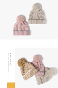 Detailed view of the thick vertical knit texture and soft faux fur pompom on this winter hat