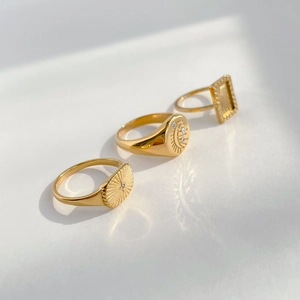 Detailed close-up of three gold sun and moon rings with sparkling cubic zirconia stones
