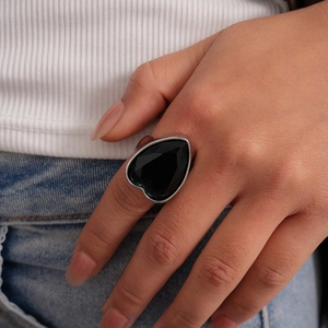 Détail d'une bague imposante en zircon noir en forme de cœur sur un anneau argenté