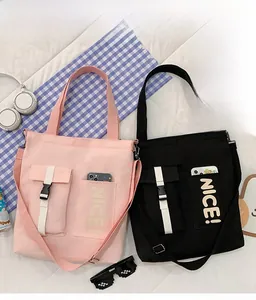Detail view of pink canvas tote bag with functional double pockets and adjustable strap