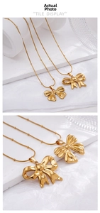 Detailed view of golden bow pendant with snake chain and bead accents on white stone