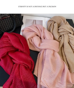 Dettaglio di sciarpe a pieghe in rosso, rosa e beige con morbida trama di seta