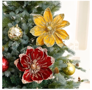 Detail of red and gold velvet Christmas flowers with glitter edges on a festive tree