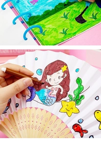 Detailed view of kids coloring set with watercolor pens, paper book and bamboo fan