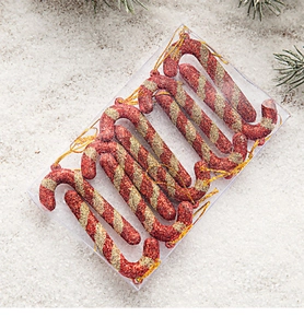 Detail of red and gold glitter candy cane ornaments in transparent gift box packaging