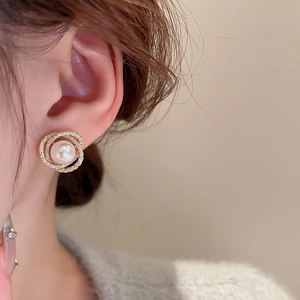 Gros plan de boucles d'oreilles perles dorées avec anneaux en zircon sur un mannequin