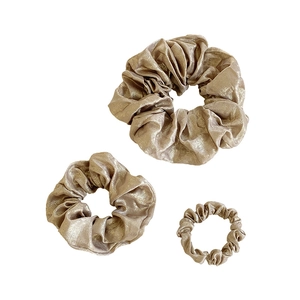 Three champagne gold metallic scrunchies in various sizes for stylish hair styling