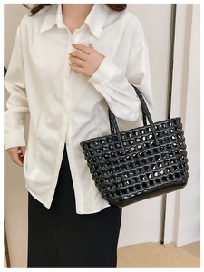 Close-up of black hollow woven jelly tote bag with glossy texture and durable handle