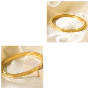 Close-up of 18k gold plated stainless steel oval bangle with starburst zircon engraving