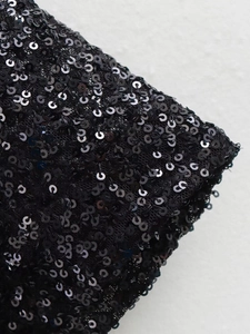 Close-up of black sequins sewn on mesh fabric showing detailed texture and craftsmanship