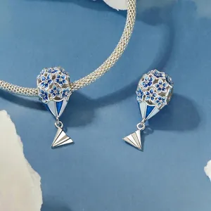 Elegant S925 sterling silver charm featuring blue enamel flowers and a paper plane pendant
