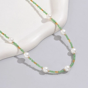 Bohemian beaded necklace featuring green glass beads, white pearls and gold metal spacers